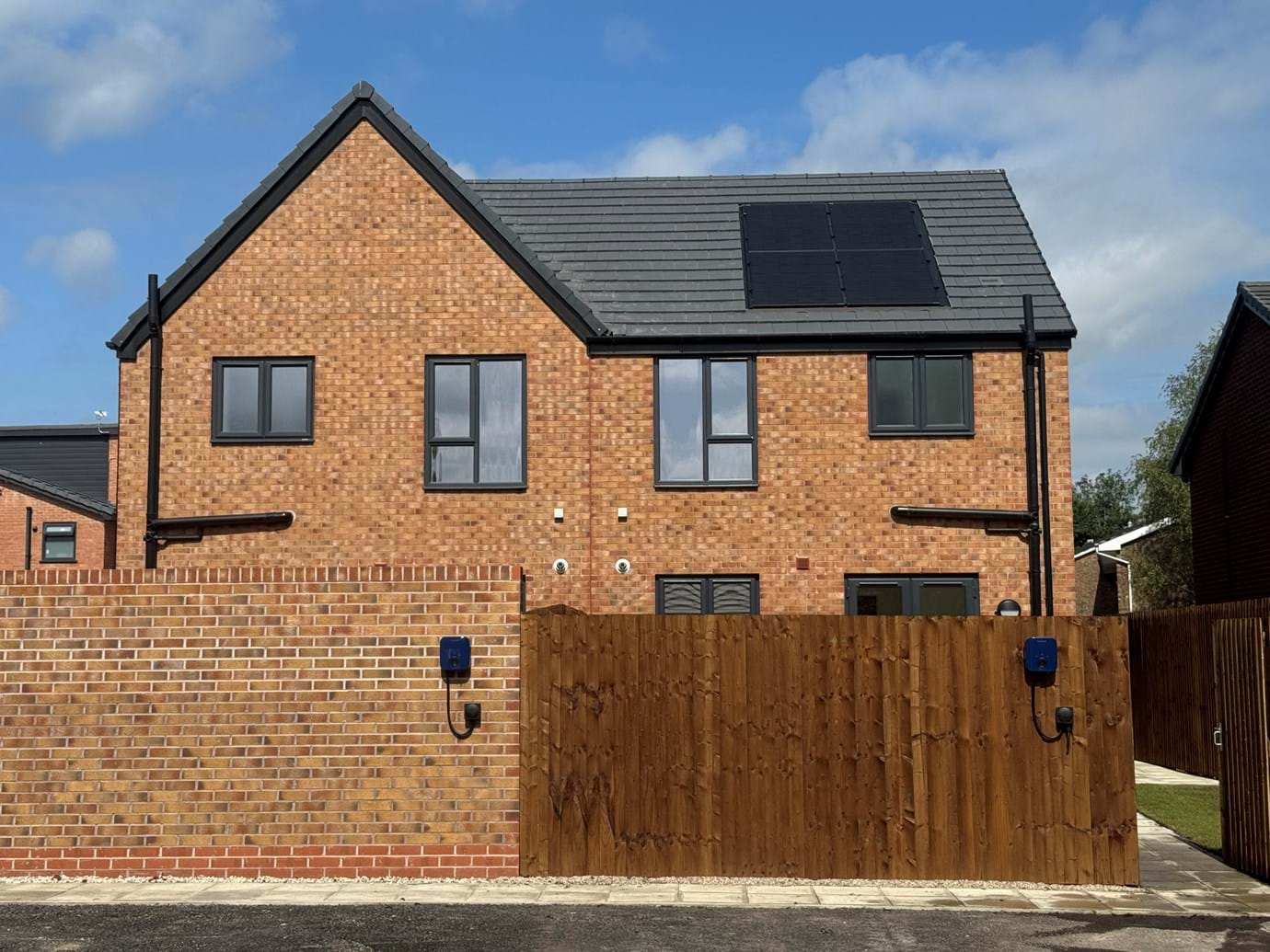 Image of the back of a property at Mossylea Close, showcasing the EV chargers and solar panels on the roof.